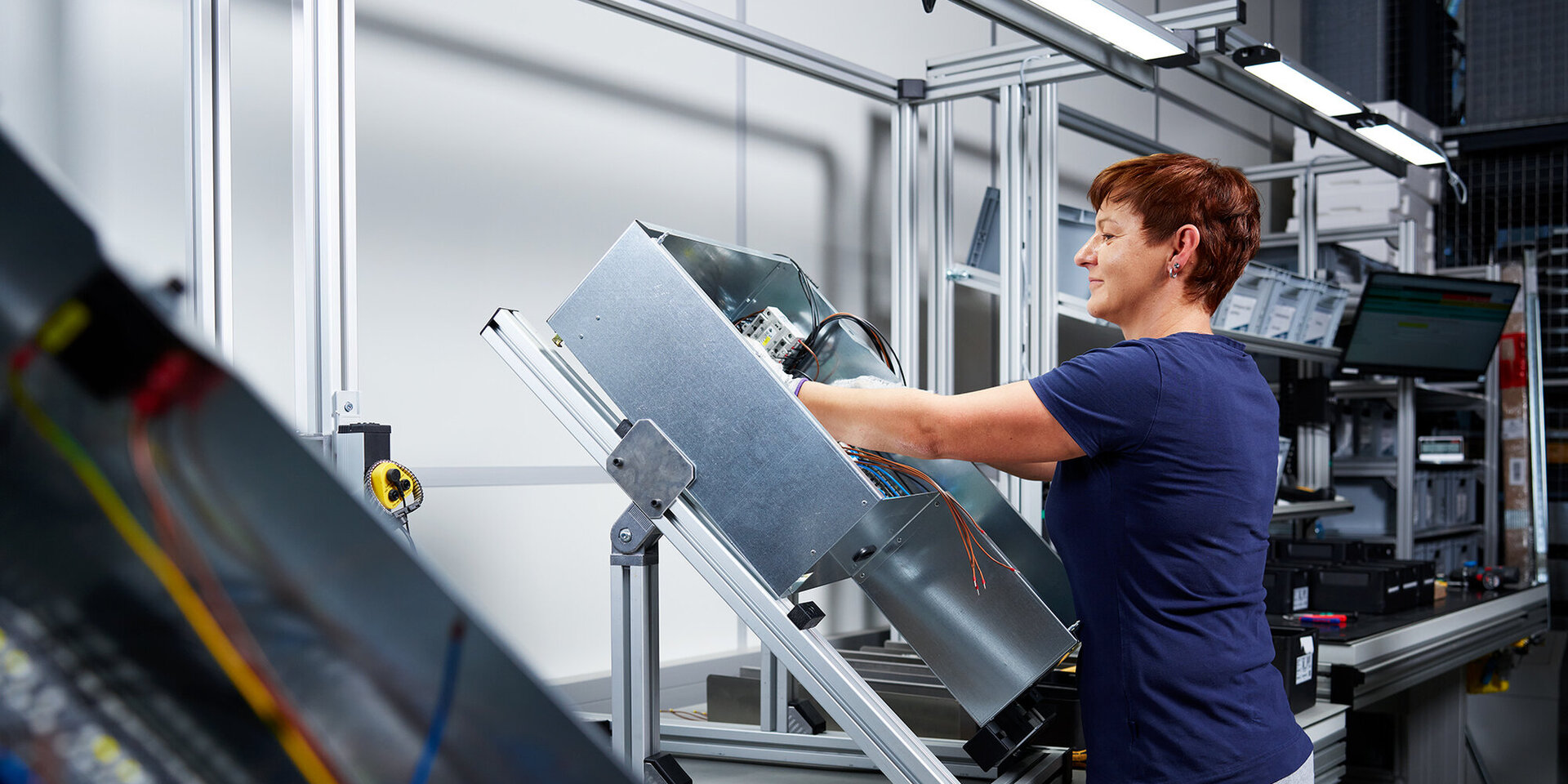 Mitarbeiterin in der Metallverarbeitung beim Montieren einer Baugruppe