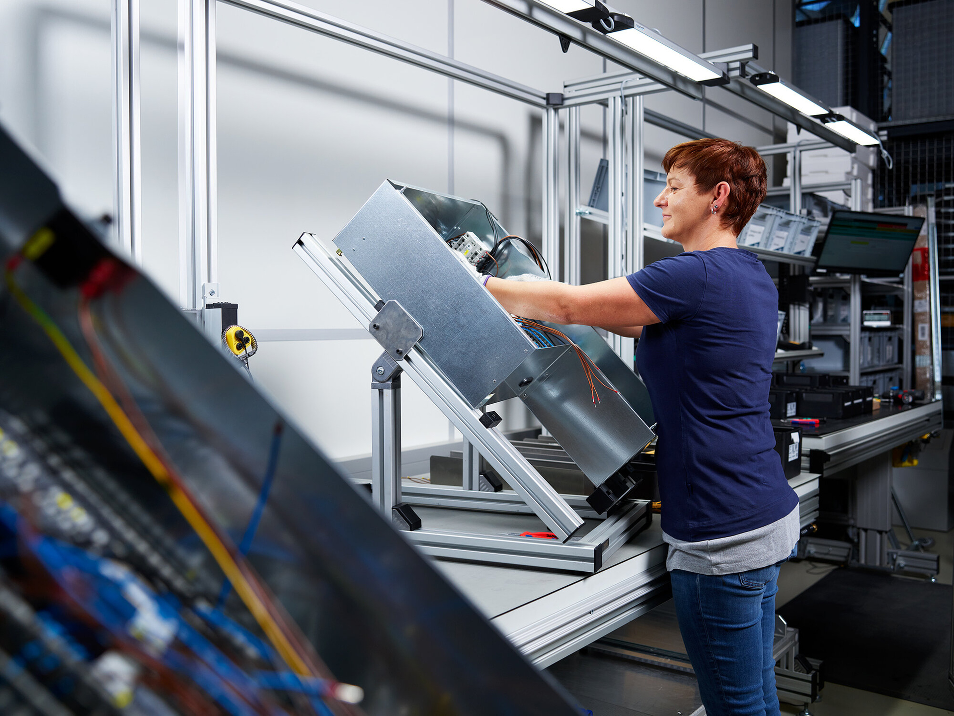 Mitarbeiterin in der Metallverarbeitung beim Montieren einer Baugruppe