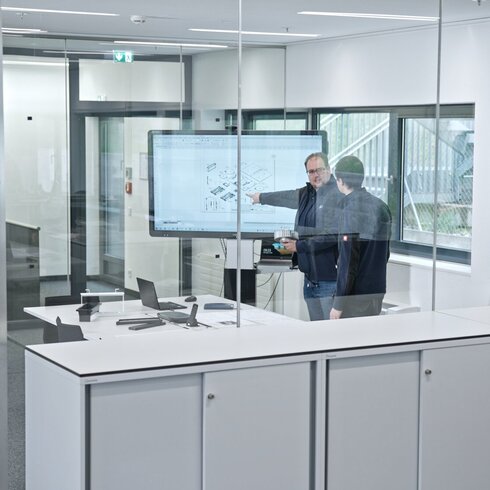 Personen bei der Entwicklung individueller Produktkonzepte anhand von Skizzen und technischen Unterlagen