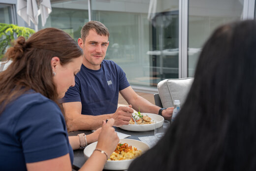 Team beim Essen in entspannter Atmosphäre auf der Dachterrasse